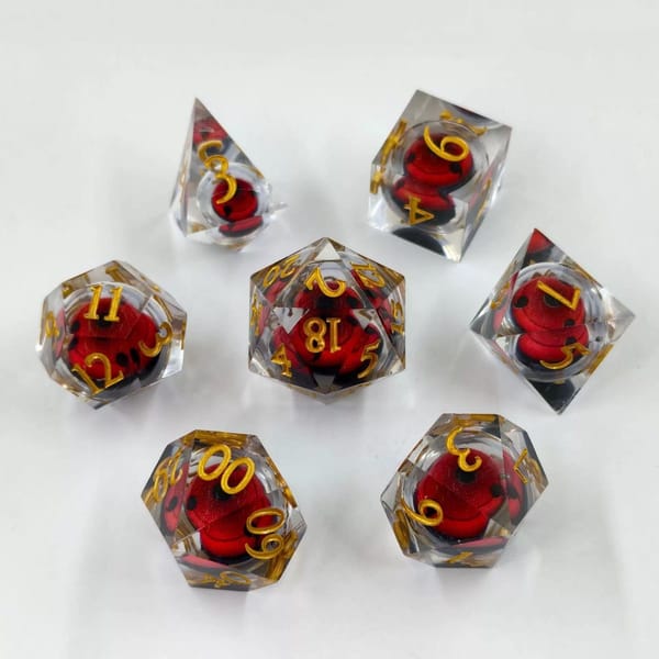 In-stock sharp-edge resin dice with a red and black liquid core and gold numbers
